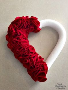 a heart made out of red ruffles sitting on top of a white table