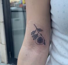 a woman's arm with a tattoo on it that has an olive and leaves on it