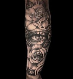 a man's leg with roses and an eye on it