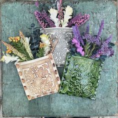 three vases filled with different types of flowers