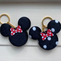 two mickey mouse keychains with red and white polka dots on them, one has a bow