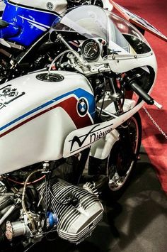 two motorcycles parked next to each other on a red carpeted area with white and blue stripes