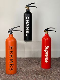 three different types of fire extinguishers are on the floor next to each other