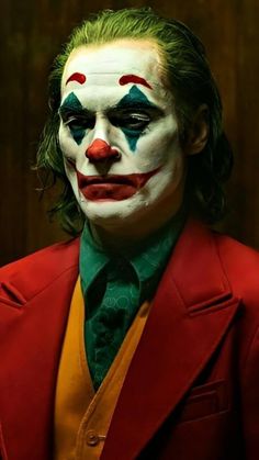 a close up of a person wearing a suit and clown makeup on their face,