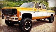 an orange and white truck is parked in the gravel