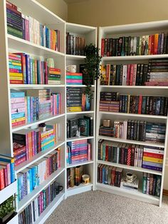 a room filled with lots of books on top of white shelves