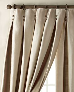 a curtain with buttons on it hanging in front of a window