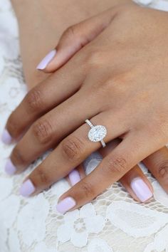 a close up of a person's hand with a ring on her finger and pink manicures