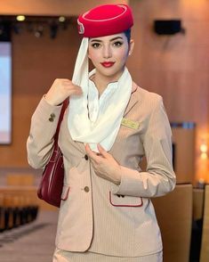 a woman in an air hostess uniform poses for the camera