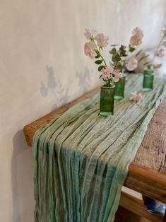 three vases with flowers are sitting on a table