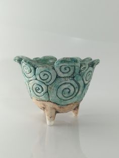 a small ceramic bowl with spiral designs on the outside and inside, sitting on a white surface