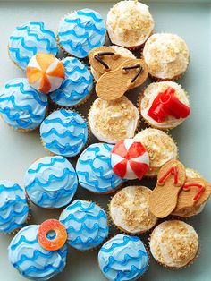 some cupcakes are decorated with blue icing and red, white, and orange decorations