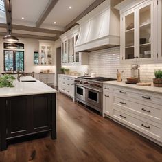 a large kitchen with white cabinets and wood floors