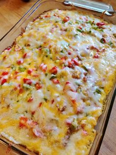 a casserole dish with cheese and vegetables in it on a wooden counter top