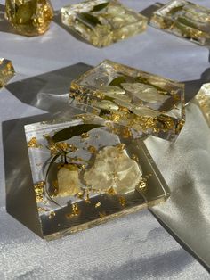 several pieces of glass sitting on top of a white table cloth covered in gold flakes