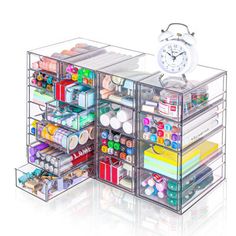 an open drawer with various items and a clock on the top one is filled with supplies