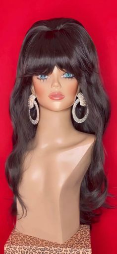 a mannequin head with long black hair and earrings on it's head