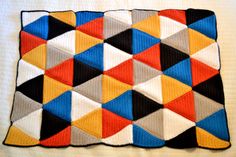 a crocheted blanket with different colored squares on it