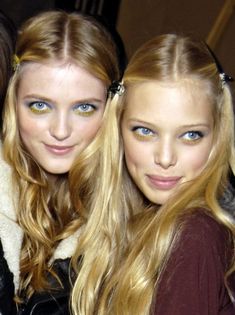 two beautiful young women standing next to each other in front of a cameraman's lens