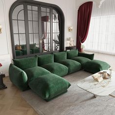 a living room filled with green couches and a large mirror on top of the wall