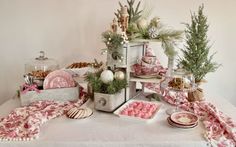 a table topped with lots of desserts next to a wooden box filled with cookies