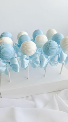 blue and white cake pops with bows on them