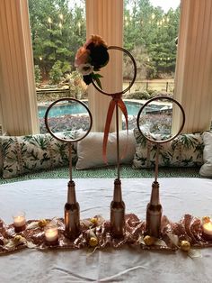 a table with candles and flowers on it in front of a window that looks out onto the pool