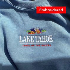 "*SIZES ARE UNISEX* -I'd suggest your usual size for a regular fit, or sizing up for a more relaxed fit. *these sweatshirts are extra comfy when oversized \"Lake Tahoe- Jewel of the Sierra\" embroidered on a comfy cute crewneck. A sturdy and warm sweatshirt bound to keep you warm in the colder months. A pre-shrunk, classic fit sweater that's made with air-jet spun yarn for a soft feel and reduced pilling. Your new favorite sweatshirt! * 50% cotton, 50% polyester * Pre-shrunk * Classic fit with n Casual Winter Sweater With Custom Embroidery, Oversized Crew Neck Sweater For Outdoor, Relaxed Fit Cotton Sweatshirt For Hiking, Vintage Embroidered Text Sweatshirt For Winter, Winter Embroidered Sweatshirt Relaxed Fit, Graphic Print Crew Neck Sweatshirt For Outdoor, Fall Crew Neck Sweatshirt For Hiking, Vintage Winter Sweatshirt With Embroidered Text, Fall Hiking Crew Neck Sweatshirt