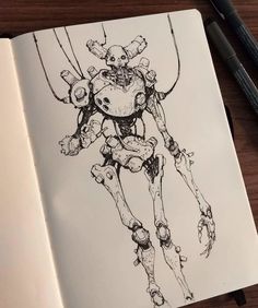 an open notebook with a drawing of a robot on it