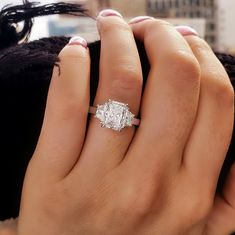 a woman's hand holding an engagement ring