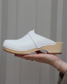 Handmade clog from Sweden. Light wooden base, Snow white leather. Classic White Round Toe Clogs, Classic White Closed Toe Clogs, Classic White Clogs With Rubber Sole, Classic White Clogs With Cushioned Footbed, Comfortable White Winter Clogs, White Round Toe Clogs For Winter, Classic White Leather Clogs, White Clogs, Wooden Base