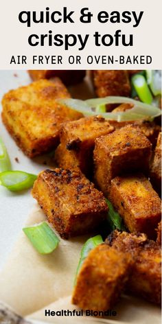 some fried tofu is on a plate with green onions