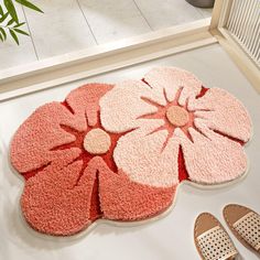 a pair of shoes and rugs on the floor in front of a potted plant