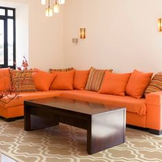 a living room filled with lots of orange furniture