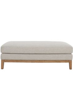 the footstool is made from wood and has a light colored fabric on it