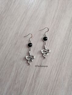 Snake earrings and black onyx stone.   Black onyx is a stone of protection, it protects from the evil eye, it repels the presence of spirits who would try to influence you, it is very useful for mediums. It promotes a sense of responsibility and helps to maintain self-control by being more composed. Dimensions: 6.3 centimeters in length (with the hook) Materials used: The ear hooks are made of stainless steel, the other metal parts are made of zinc alloy and onyx stone (each natural stone being Black Dangle Halloween Jewelry, Handmade Black Metal Jewelry, Gothic Sterling Silver Adjustable Earrings, Witchy Black Jewelry For Halloween, Black Witchy Jewelry For Halloween, Adjustable Gothic Earrings, Witchy Black Halloween Jewelry, Gothic Black Drop Earrings, Black Wire Wrapped Metal Earrings