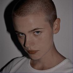 a young man with blue eyes wearing a white t - shirt