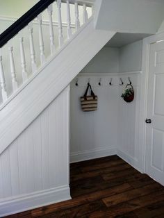 there is a coat rack under the stairs