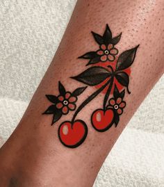 a tattoo on the leg of a woman with cherries