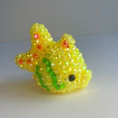 there is a yellow bear made out of beads