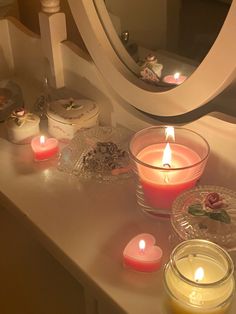 some candles are sitting on a table next to a mirror