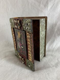 an ornate wooden box with decorative designs on the front and sides, set against a white background