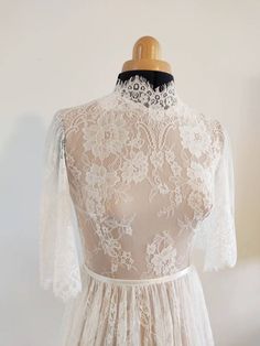 the back of a white dress on a mannequin headdress with lace