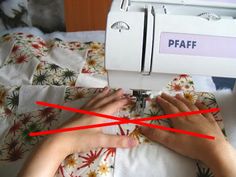 a woman is using a sewing machine to sew on the bed sheet with red lines