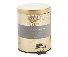 a gold and silver canister with a label on the lid that says trademark