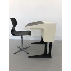 an office desk with a chair next to it on top of a carpeted floor