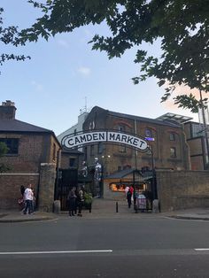 people are standing outside the camden market on a sunny day with blue skies in the background