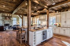 a large kitchen with an island in the middle and lots of wood on the ceiling