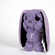 a purple stuffed animal with black ears and eyes