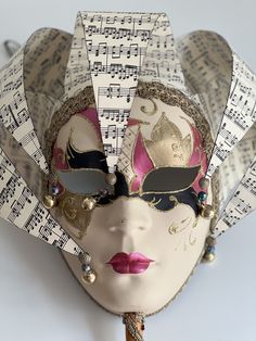 a masquerade mask with sheet music notes on it's face and eyes